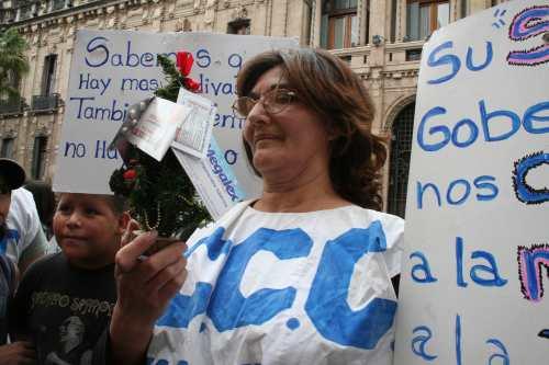 Una militantes de la CCC sostiene un arbolito de navidad