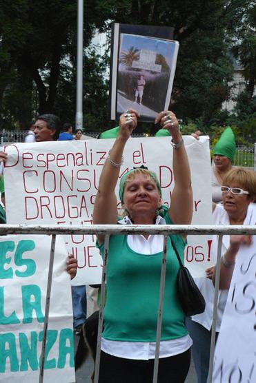 Sostiene a lo alto una foto de una de las tantas víctimas del paco