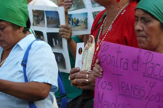 Una de las madres sosteniendo una Virgen mientras marchaba