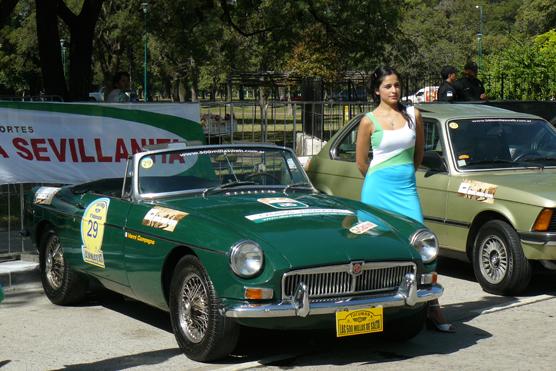 Una hermosa promotora junto a uno de los autos de la competición