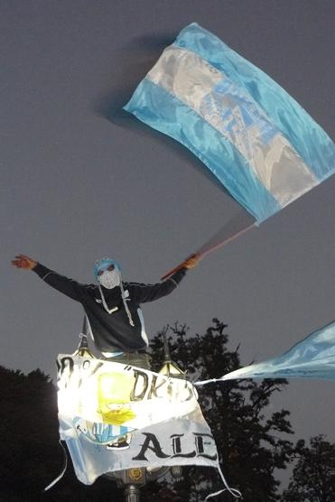 El hombre araña dekano flameaba su bandera trepado en un farol de la plaza