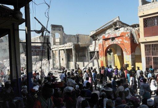 Haitianos caminan frente a las ruinas de edificios colapsados ayer en Puerto Príncipe