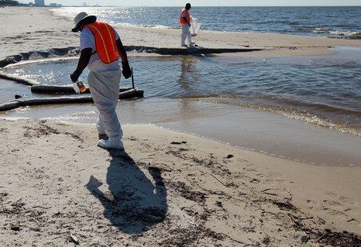 Operarios recorren una playa en Biloxi, Mississippi