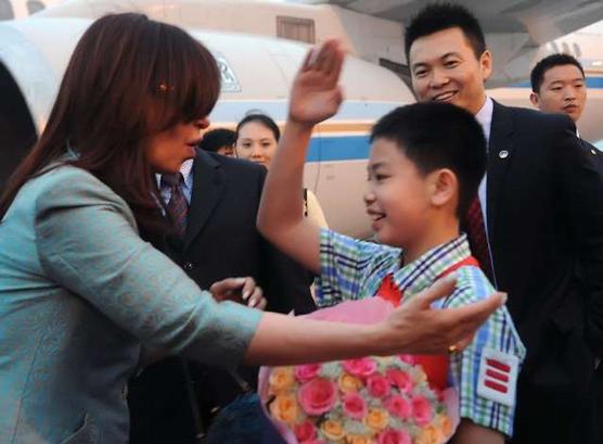 Un joven chino le entrega a Cristina un ramo de flores 