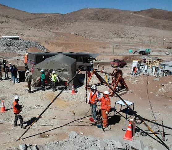 Trabajadores del equipo de rescate, con uno de los conductos.