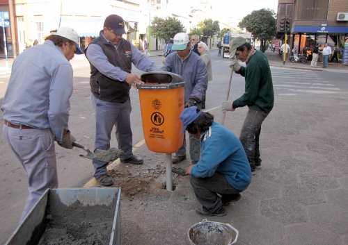 Operarios instalan nuevos cestos