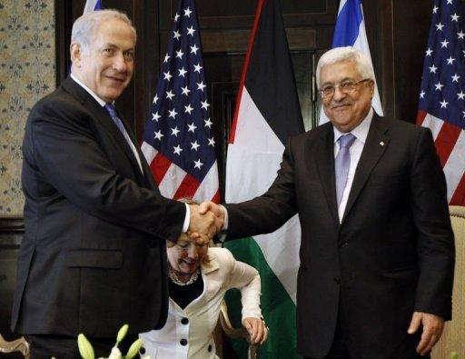 El primer ministro israelí, Benjamin Netanyahu (I), y el de la Autoridad palestina, Mahmud Abas, se estrechan la mano