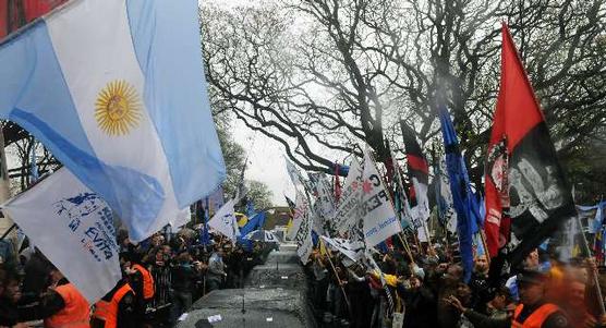 Bajo una intensa lluvia, una multitud expresa su apoyo acompañando la llegada de los restos del ex mandatario a aeroparque