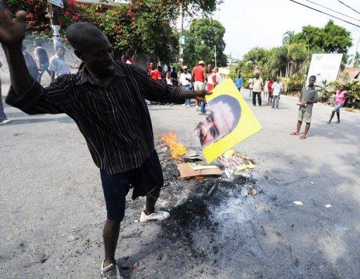 Partidarios del candidato Michel Martelly queman pósters de Jude Celestin ayer en Puerto Príncip