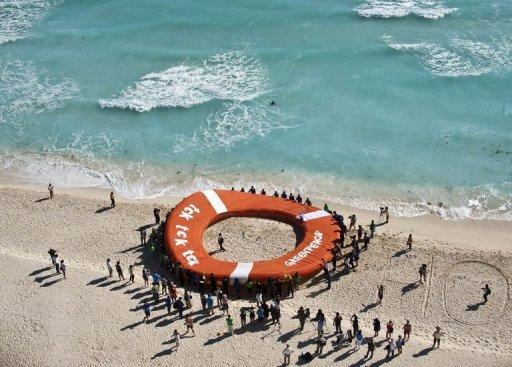 Greenpeace utiliza un salvavidas gigante en una playa de Cancún