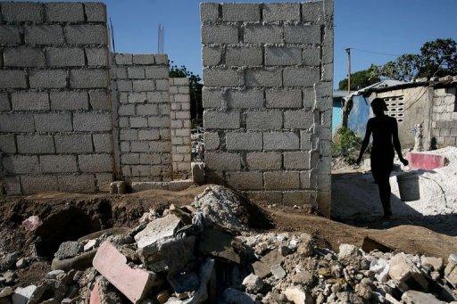 Una mujer camina junto a un muro recién construido en Puerto Príncipe