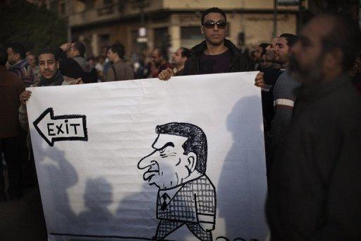 Manifestantes sostienen un cartel con una caricatura del presidente egipcio Hosni Mubarak en la plaza Tahrir