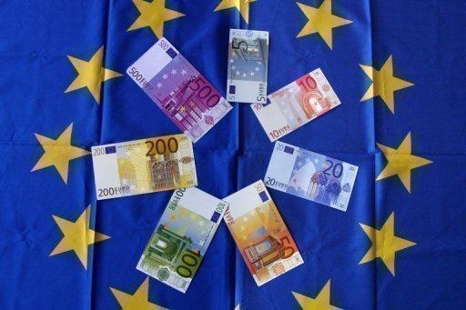 Billetes de euro sobre una bandera de la Unión Europea  