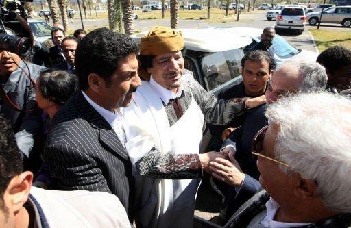 El líder libio Muamar Gadafi llega a una ceremonia en Trípoli ayer