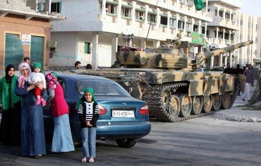 Civiles junto a un tanque el ejército libio en Zawiya, a 40 km de Trípoli