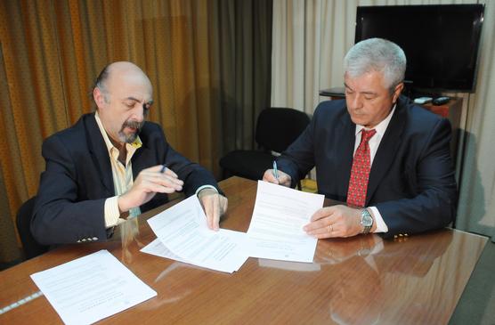 Los funcionarios firmando convenio