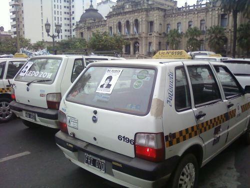 Taxis con la aficheta en su luneta trasera