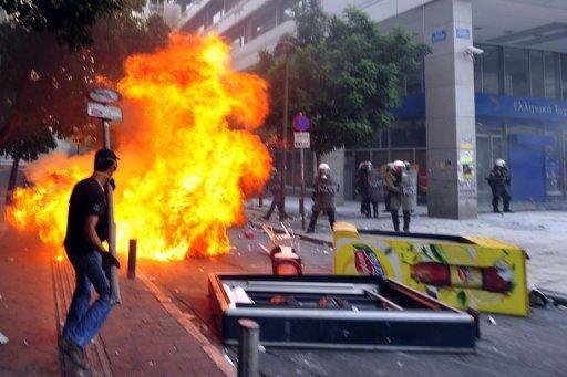 Un manifestante ante la policía antidisturbios, en Atenas, ayer