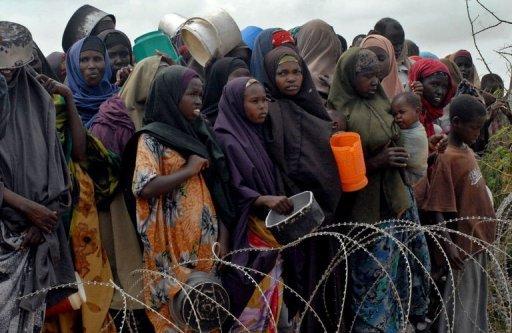 Varios somalíes desplazados esperan a recibir alimentos en un campamento de refugiados