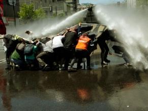 Carro hidrante lanza agua coloreada a los estudiantes