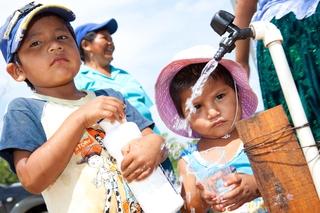 Niños ante un grifo comunitario