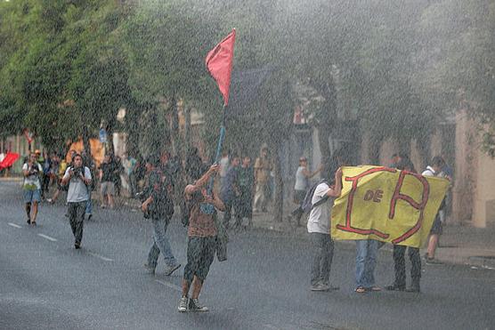 Estudiantes marchan en medio de una lluvia de gases