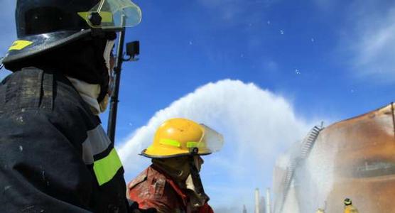 Bomberos lanzan agua a los tanques incendiados