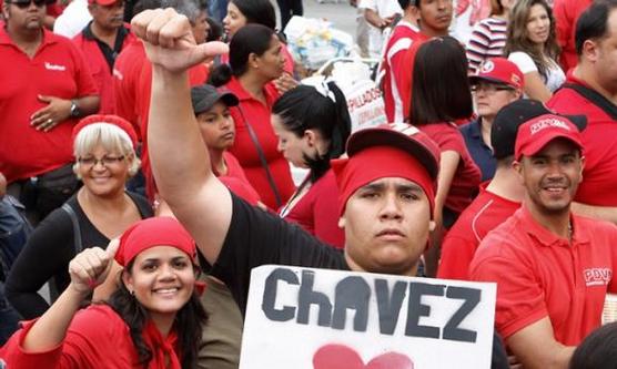 Jovenes agitan carteles a favor de Chavez