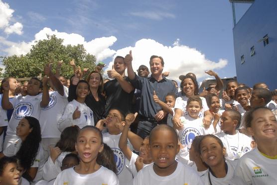 Cameron rodeado de alumnos en una favela