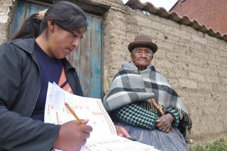 Una señora recibe a una censista en El Alto