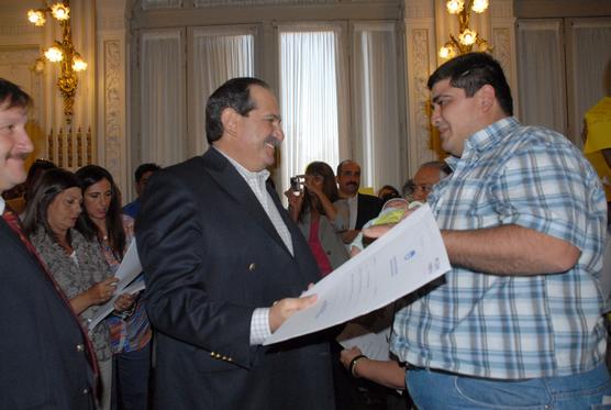 Vecinos recibiendo su escritura de manos de Alperovich