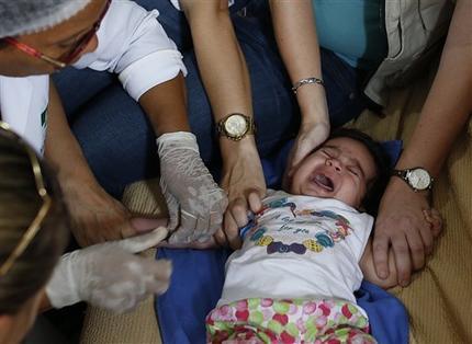 Trabajadores de Brasil y de Estados Unidos le sacan sangre a una bebé de tres meses, Esther Kamily, en su casa de Joao Pessoa