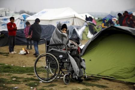 Un refugiado sirio en silla de ruedas en campamento griego