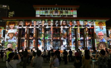 Personas mirando un show de luces que anuncia la realización de la cumbre G20 en el próximo mes, en Hangzhou.