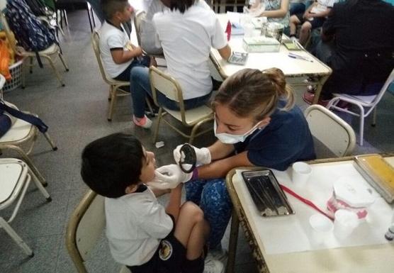 Una profesional enseña a los niños a cuidar y mantener su salud bucal