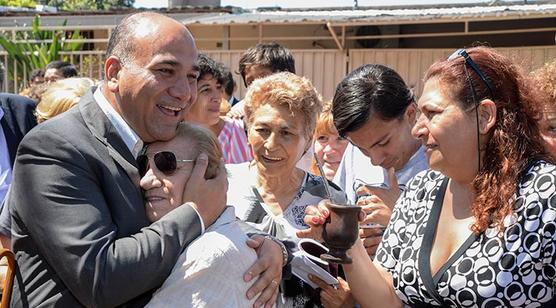 Manzur abrazado por vecinas