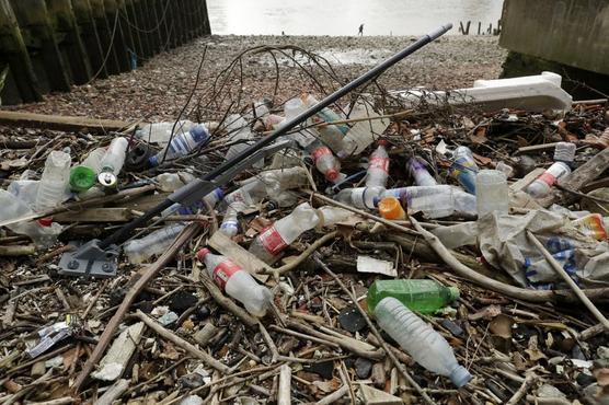 Botellas y otras piezas fabricadas con plástico flotan frente a una playa