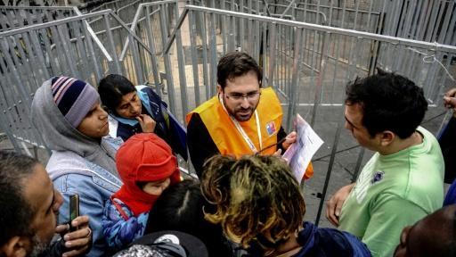 Migrantes conversan con un trabajador de migración chileno