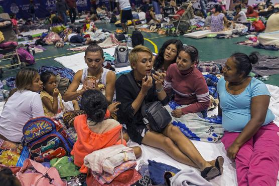 Mujeres transgenero se maquillan entre otras migrantes