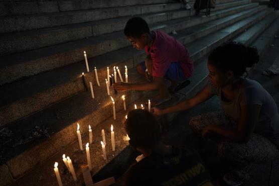 Parientes prenden velas en la iglesia