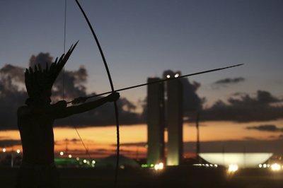 Indígena Prataxo tensa su arco, con el Congreso de Brasil como trasfondo, durante una protesta de tres días en Brasilia