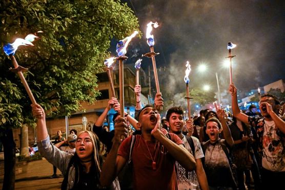 Estudiantes gritan consignas en una marcha con antorchas en Cali, Colombia, el sábado pasado
