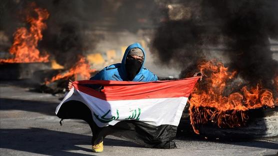 Manifestante con bandera irakí que no quiere que  Irak se convierta en el escenario de la guerra en Irán y EEUU.