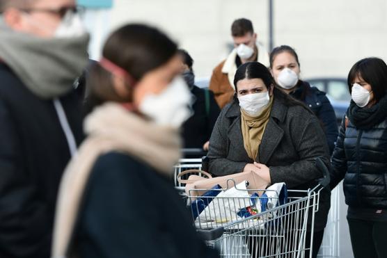 Clientes con mascarillas protectoras guardan cola para entrar en un supermercado de la localidad italiana de Casalpusterlengo