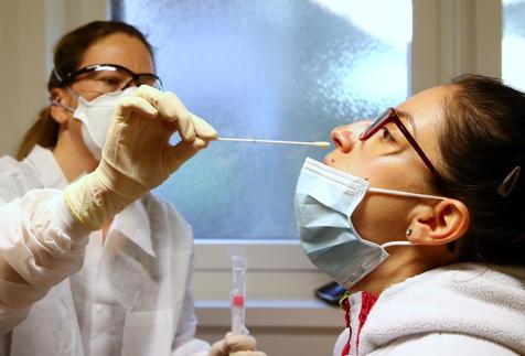 Una médica toma una muestra de mucosa a una paciente sospechada de portar el Covid-19 en Suiza (foto: ANSA)