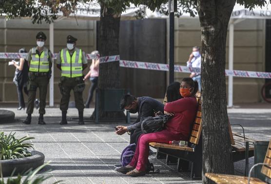 La policía monta guardia sobre una mujer, a la derecha, que está contagiada con coronavirus 