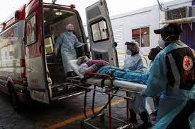 Profesionales de la salud ingresan a un ambulancia a un paciente con síntomas de COVID-19, en Sao Paulo