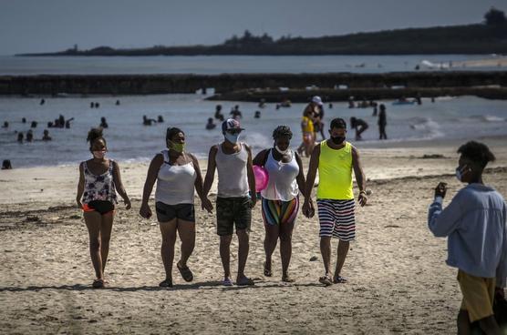 Bañistas con tapabocas en una playa de La Habana