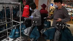 Bolsas de entregada de compradores en línea, en un supermercado 7Fresh durante la Fiesta de los Solteros en Pekín