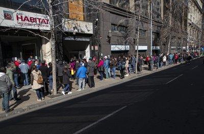 La gente espera afuera de una administradora de pensiones para solicitar un retiro anticipado